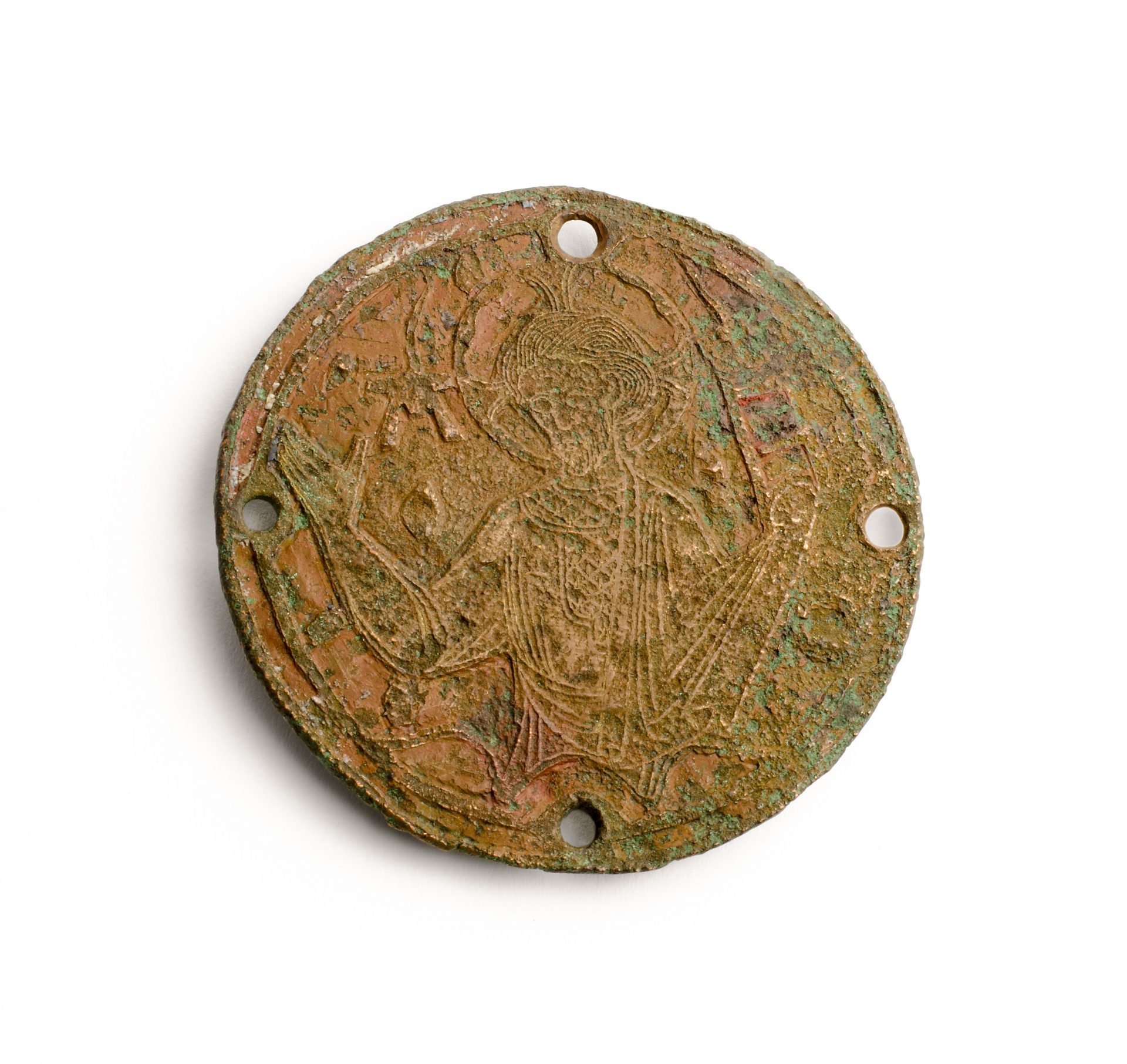 En rund metallplatta med ett motiv i relief och fyra hål i kanterna.