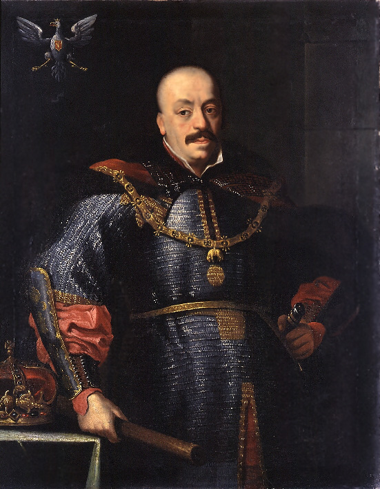 Johan II är klädd i lång ringbrynja med stora smycken. I höger hand håller han en stav.