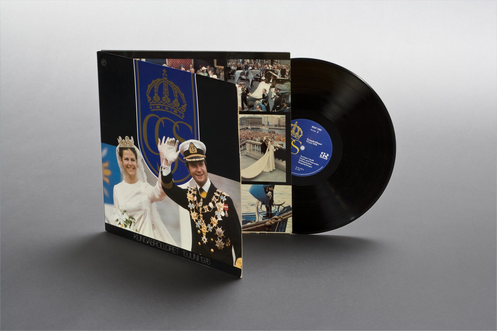 LP-skiva som sticker ut ur sitt fodral. På fodralet ser man Kung Carl XVI Gustaf och Drottning Silvia i bröllopskläder. De vinkar och ler.