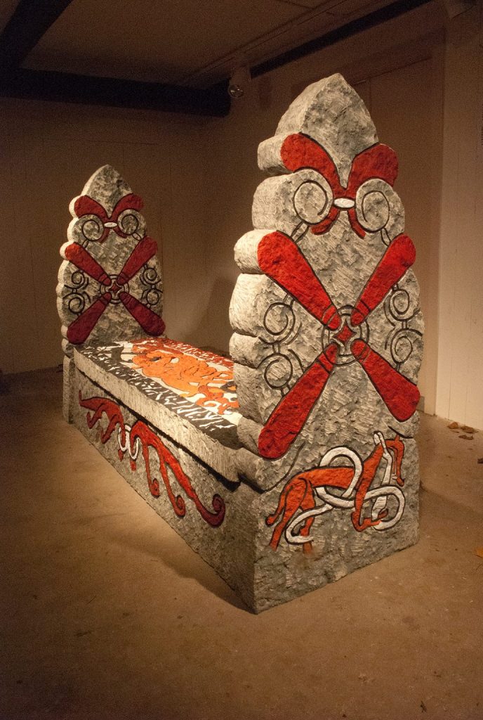 Kista av sten från grav målad med röda, svarta och vita kors och djurmönster