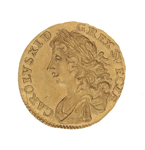 Ett guldmynt. I mitten en bild av en person med lockigt hår och lagerkrans. Runt om texten "Carolus X IDG Rex Sveciae".
