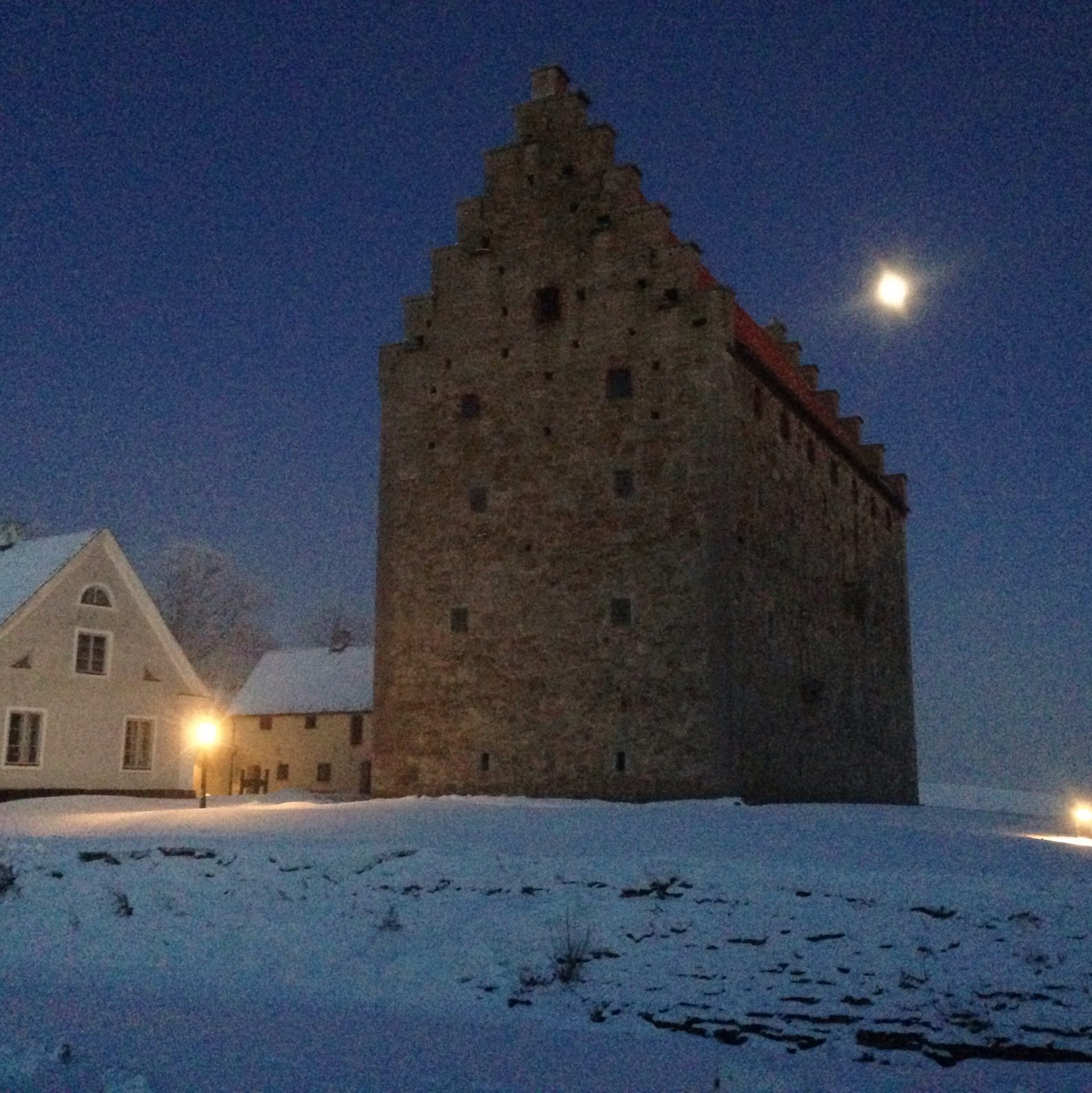 Borgen Glimmingehus fotograferad på natten med månen i bakgrunden.