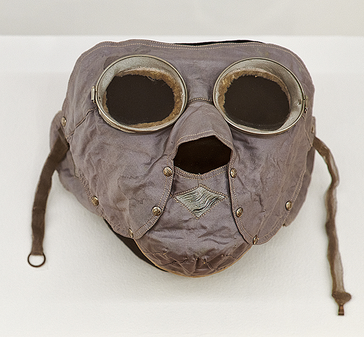 En ansiktsmask av tyg med glas för ögonen och hål för näsan. Två remmar i öronhöjd används för att spänna fast masken bakom nacken.