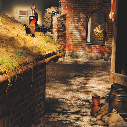 Interiör från Medeltidsmuseum som föreställer en gammal gata med hus med grästak.
