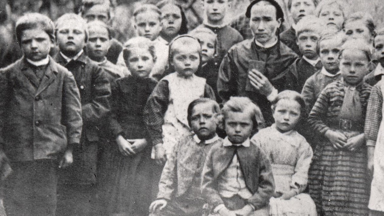 En mängd barn som står runt sin lärarinna.