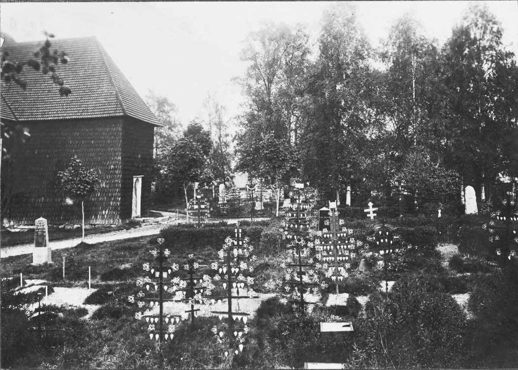 Ett svartvitt foto av en kyrkogård med gravkors.