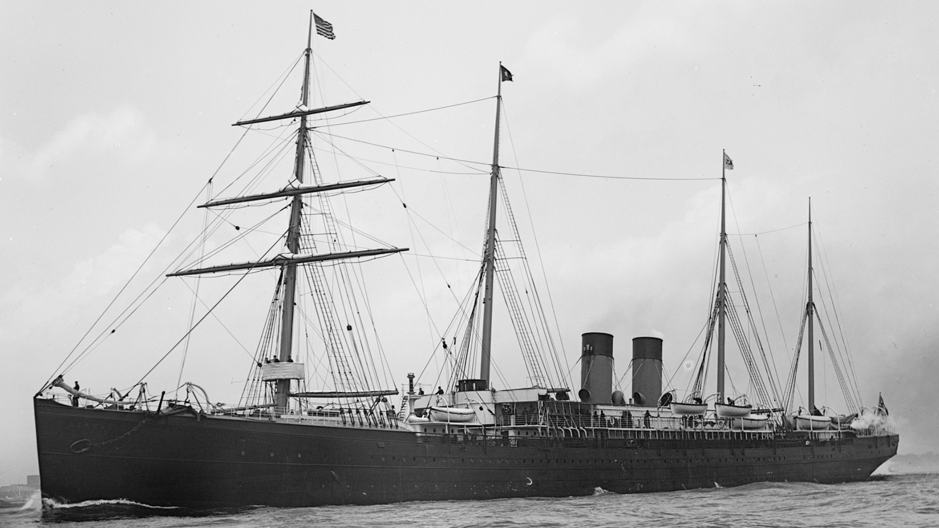 Svartvitt foto av ett ångfartyg med två skorstenar och fyra master.
