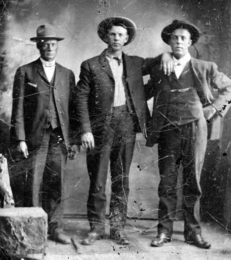 Svartvitt fotografi av tre män i kostymer och hattar.