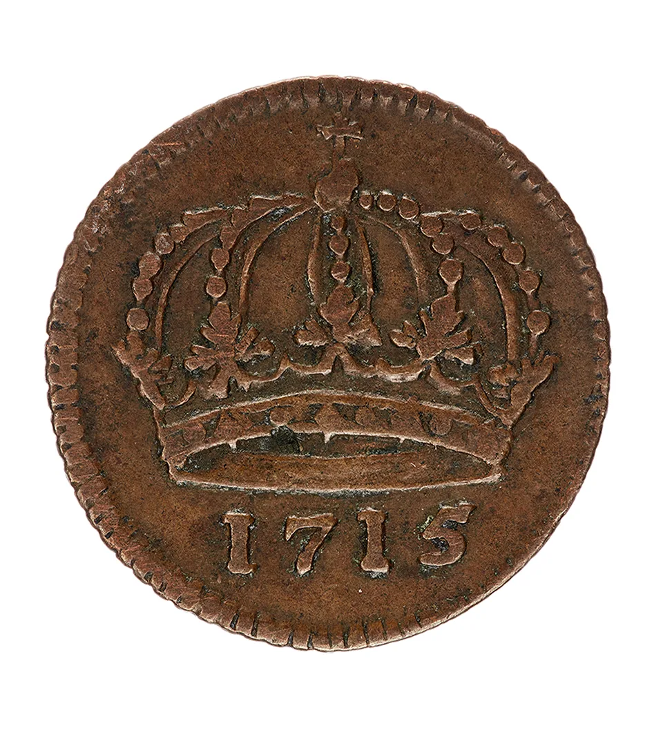 Kopparmynt med en kunglig krona och året 1715 i relief.